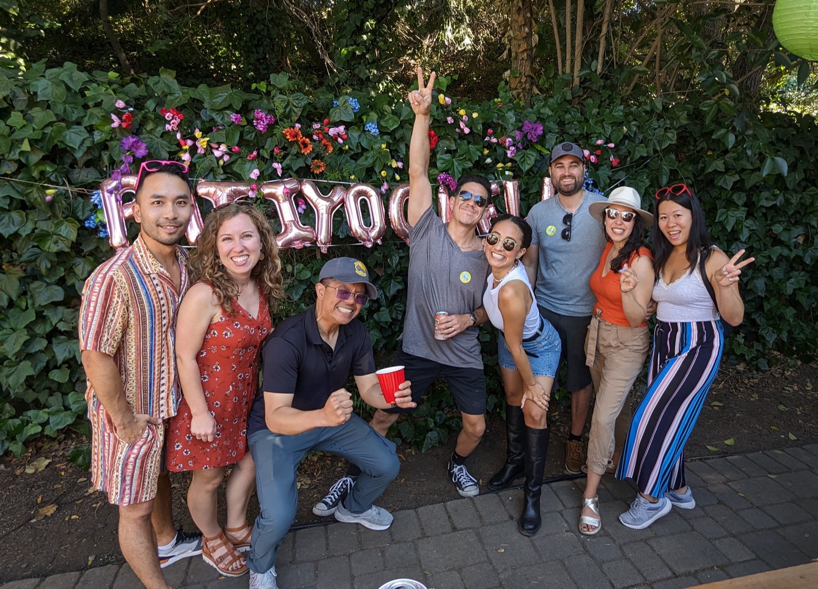 A group of friends posing in front of the Patiyochella balloon sign